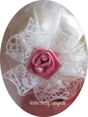 Bouquet Shabby Chic com rosas e peónias em cetim tom rosa velho, com apliques de bijuteria e plumas brancas. Pé forrado a cetim e renda branca com aplique prateado com pérola